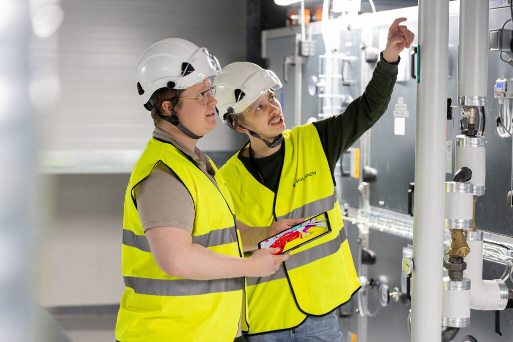 Kaksi suunnittelijaa katsovat iv-konetta